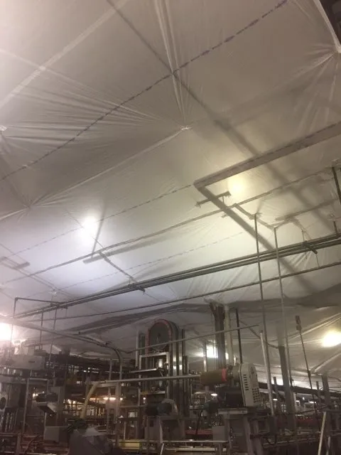 A factory floor with temporary suspended ceiling covers above